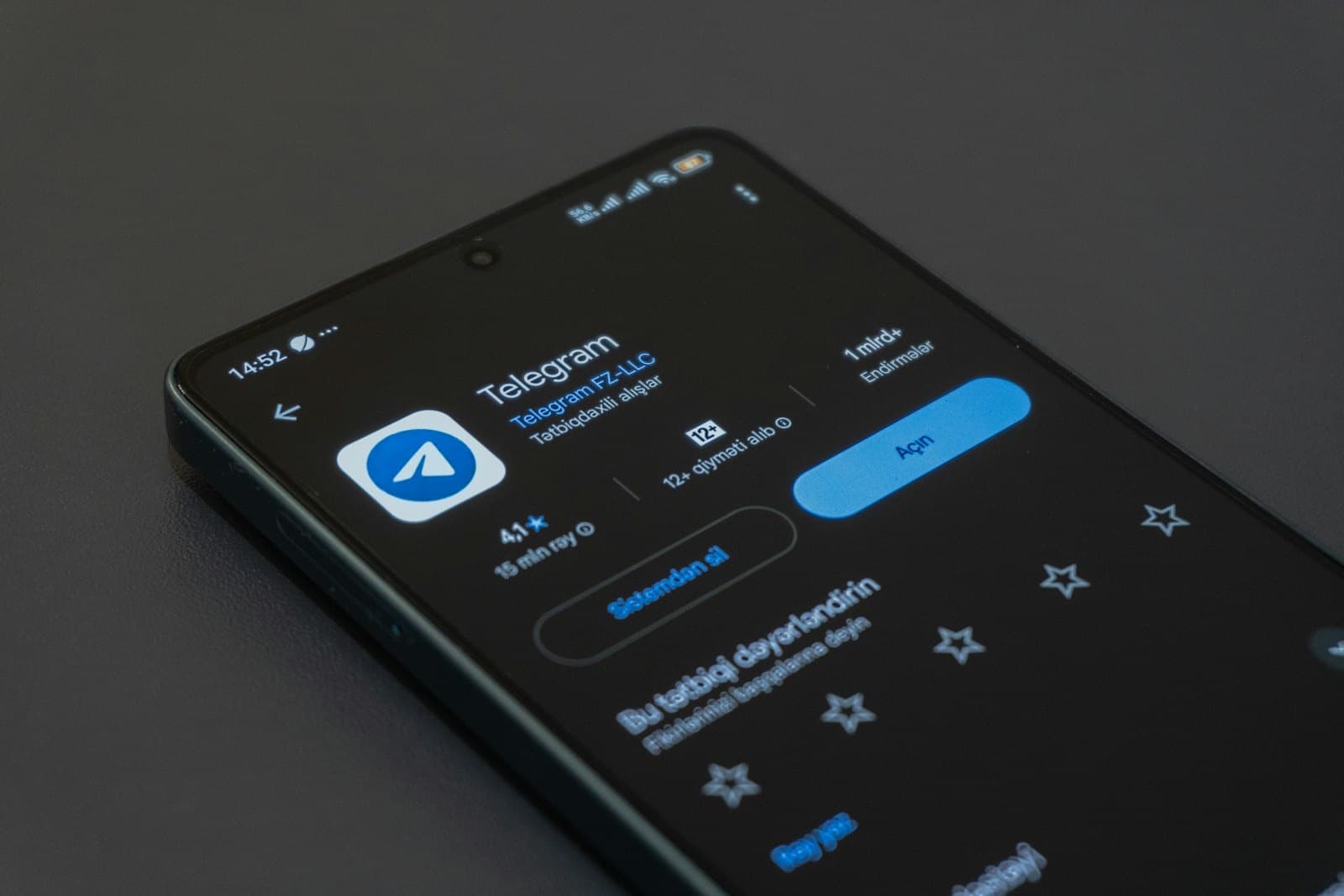 Uno smartphone appoggiato su un tavolo scuro mostra la pagina dell'app Telegram nello store.
